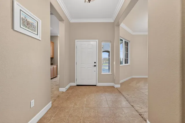 a view of an empty room with a fireplace and a ceiling fan