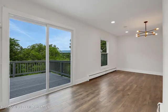 a view of a room with wooden floor and a window