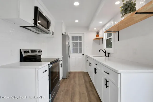 a kitchen with stainless steel appliances a sink stove and refrigerator