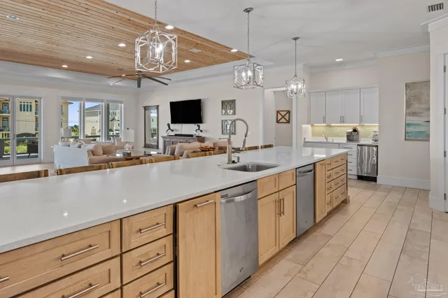a living room with furniture a chandelier and kitchen view