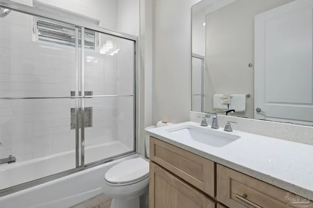 a bathroom with a toilet sink vanity and shower