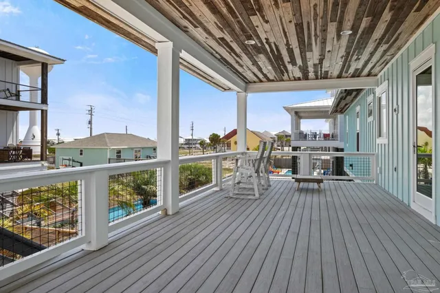 a view of a porch with a bench and wooden floor
