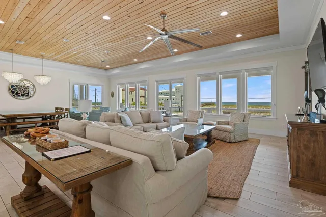 a living room with furniture kitchen view and a flat screen tv