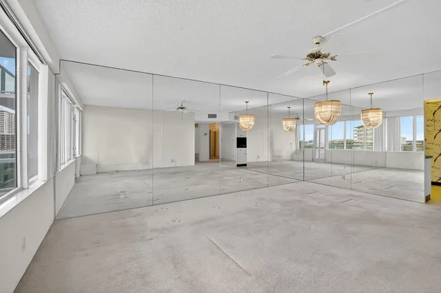 a view of a livingroom with a furniture a ceiling fan and window