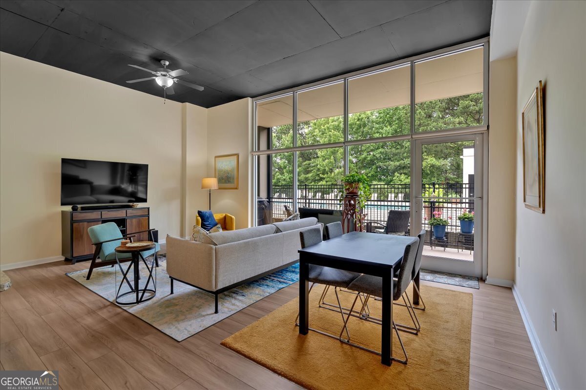 a living room with furniture a large window and wooden floor