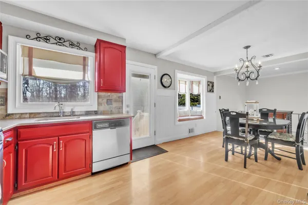 a kitchen with stainless steel appliances granite countertop a kitchen island hardwood floor sink stove dining table and chairs
