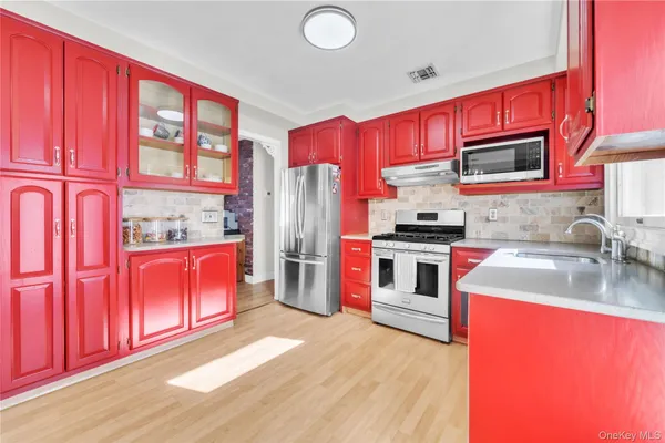 a kitchen with stainless steel appliances granite countertop a refrigerator stove top oven and sink