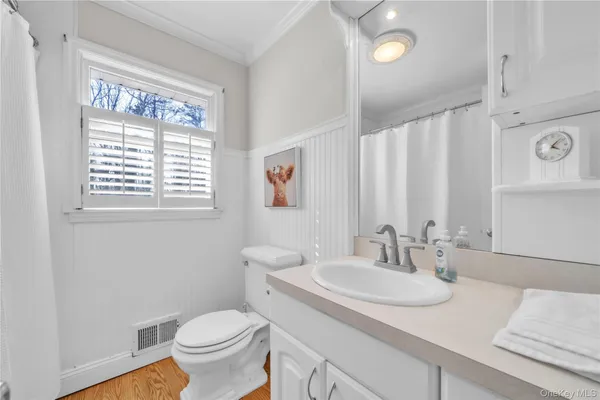 a bathroom with a granite countertop sink and a toilet
