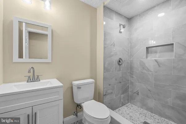 a bathroom with a sink a toilet and shower