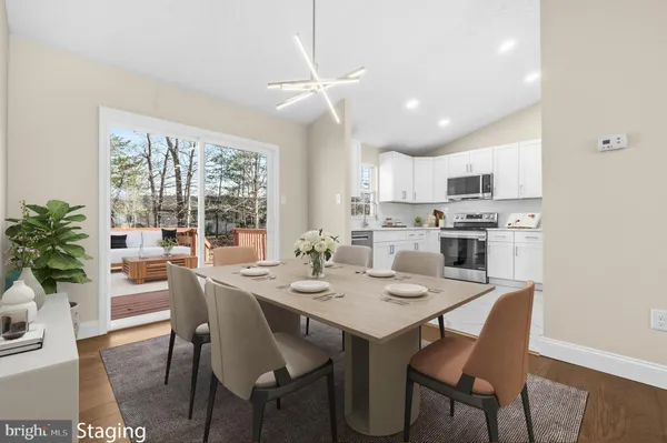a dining room with a table chairs and a kitchen view