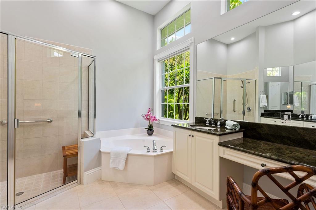 566 Eagle Creek Drive Naples, FL 34113 - Photo 12 of 25 a large bathroom with a double vanity sink a mirror and a bathtub
