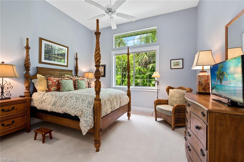 566 Eagle Creek Drive Naples, FL 34113 - Photo 14 of 25 a bedroom with a bed and a flat tv screen on dresser