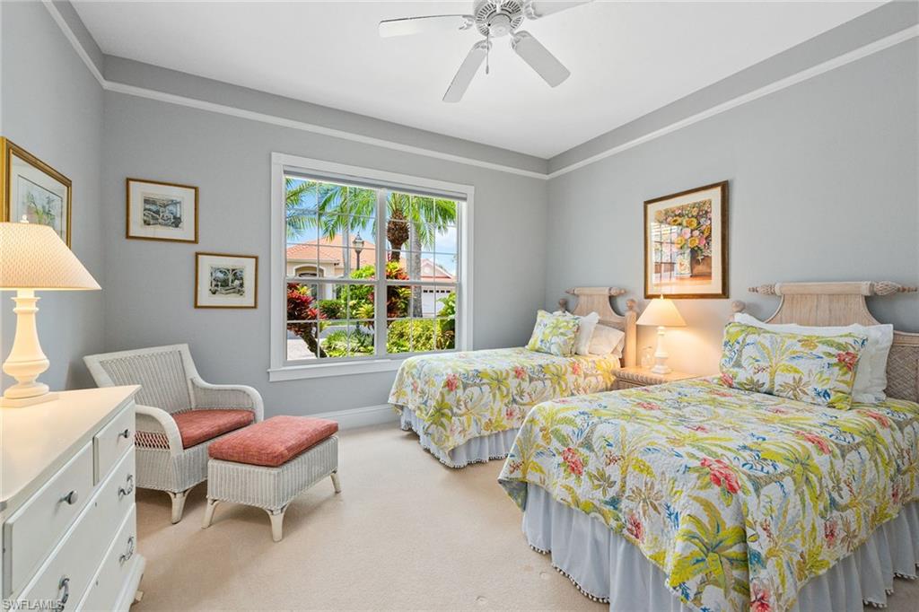 566 Eagle Creek Drive Naples, FL 34113 - Photo 16 of 25 a bedroom with two beds and a chandelier