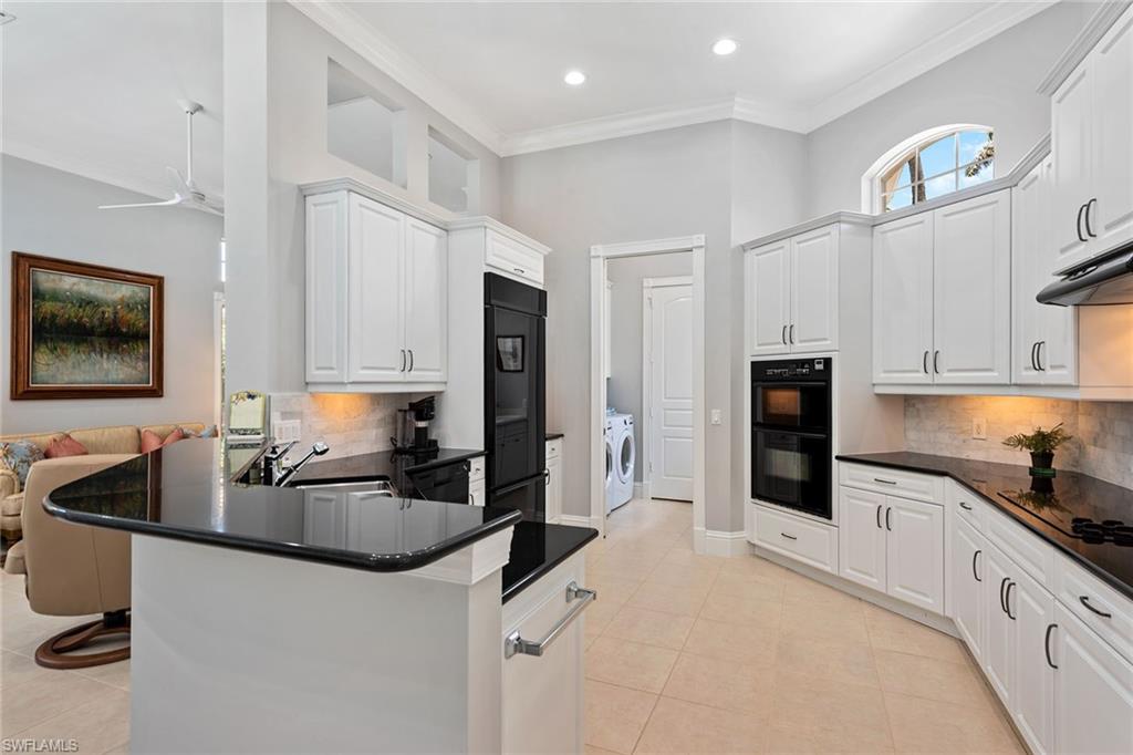 566 Eagle Creek Drive Naples, FL 34113 - Photo 5 of 25 a kitchen with granite countertop a sink appliances and cabinets