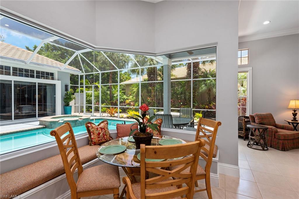 566 Eagle Creek Drive Naples, FL 34113 - Photo 7 of 25 a dining room with furniture large windows and a chandelier