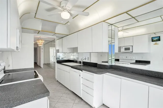 a kitchen with stainless steel appliances granite countertop a sink a stove and cabinets