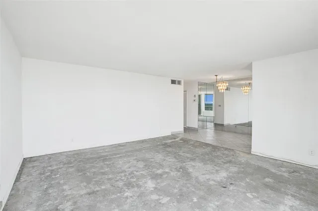 an empty room with a empty space and windows