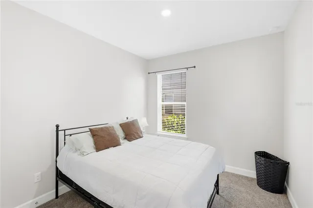 a living room with furniture a flat screen tv and floor to ceiling window