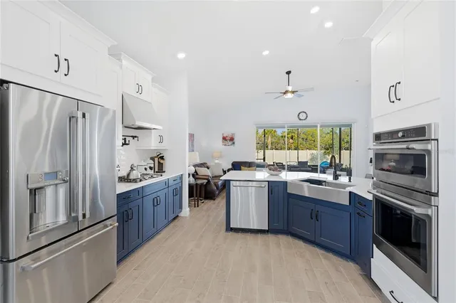 a living room with furniture a flat screen tv and kitchen view