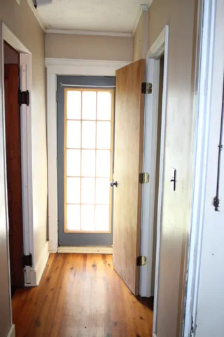 an empty room with wooden floor and a window