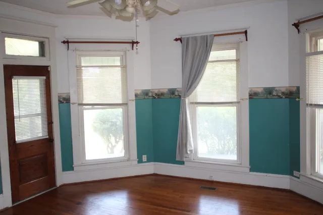 an empty room with wooden floor and a window