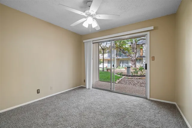 en empty room with windows and ceiling fan