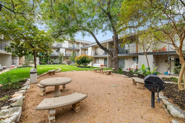 a view of a patio with a table and chairs under an umbrella