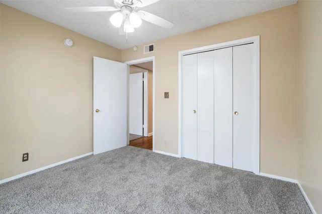 a view of an empty room and chandelier fan