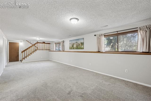 7233 River Bend Road Colorado Springs, CO 80911 - Photo 25 of 44 lower level family room all new carpet and curtains. Wood burning fireplace. New paint