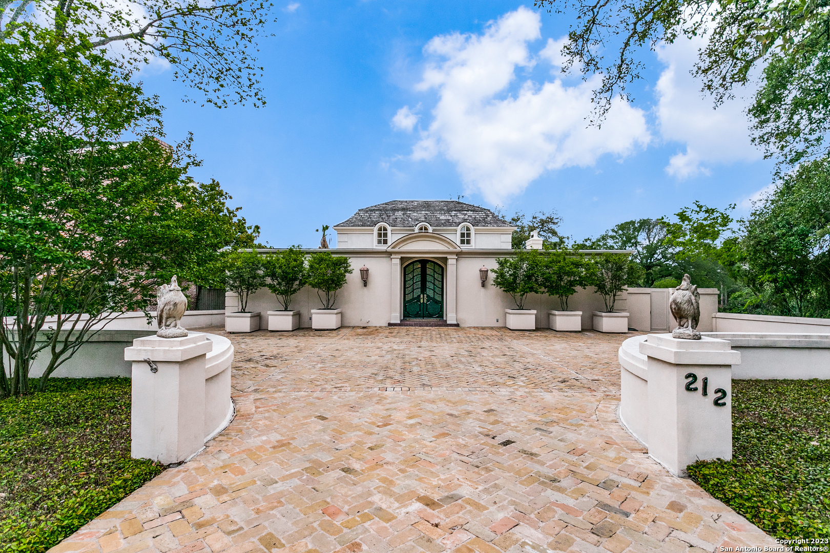 a front view of a house with fountain and barbeque oven