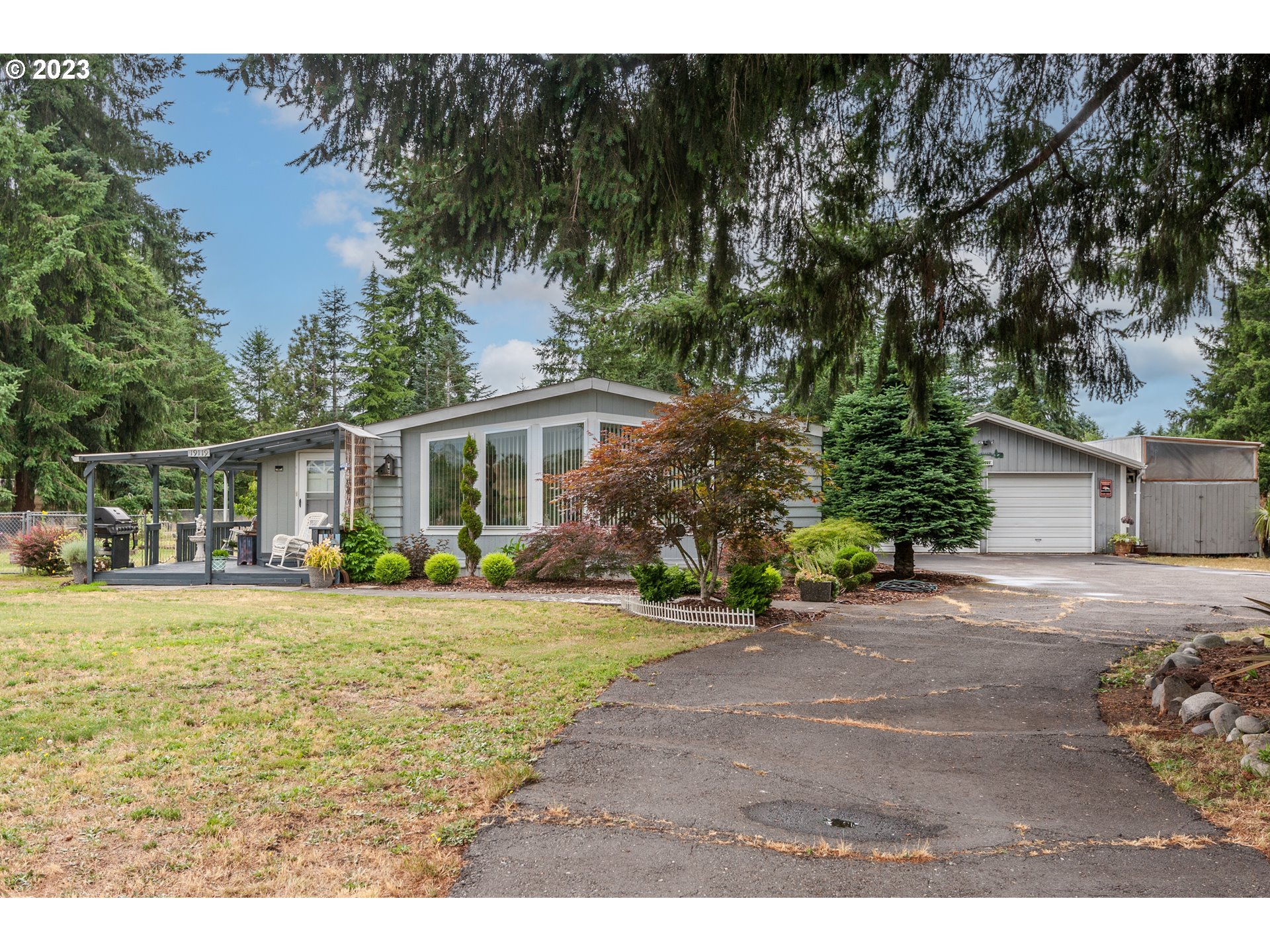 a front view of house with yard and trees around