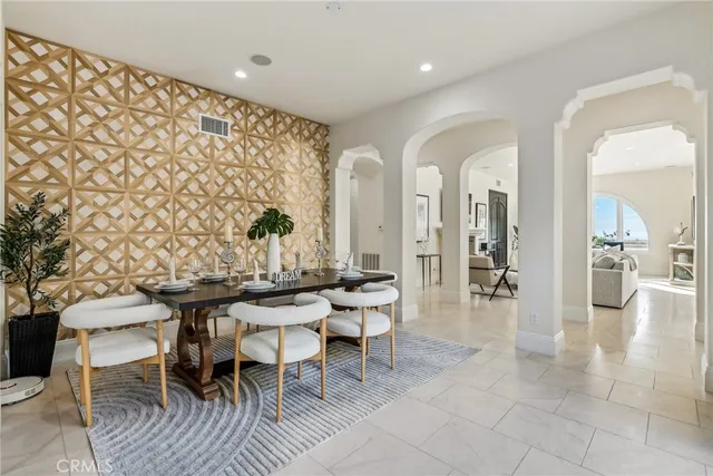 a hall with kitchen island a fireplace and a view of living room