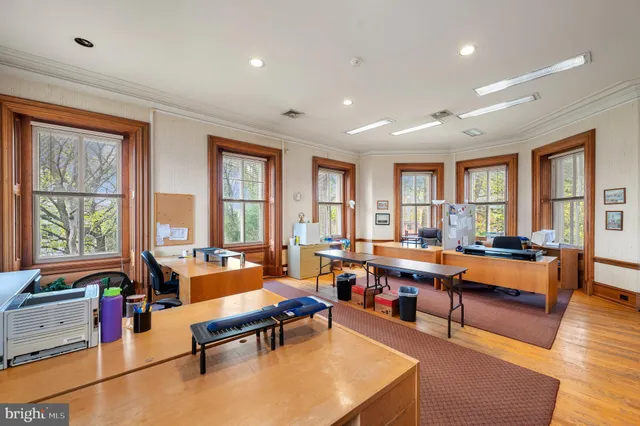 a living room with furniture large window and wooden floor