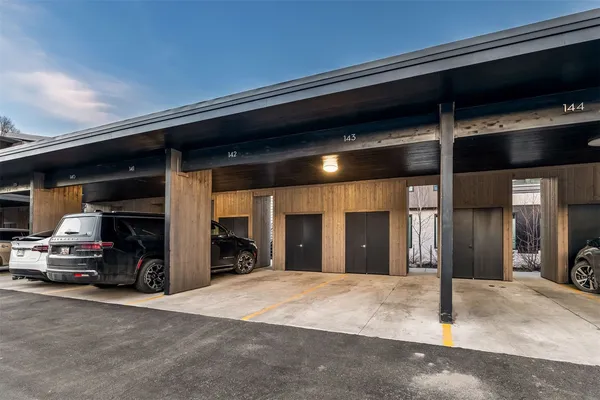 a living room with furniture a flat screen tv and a refrigerator