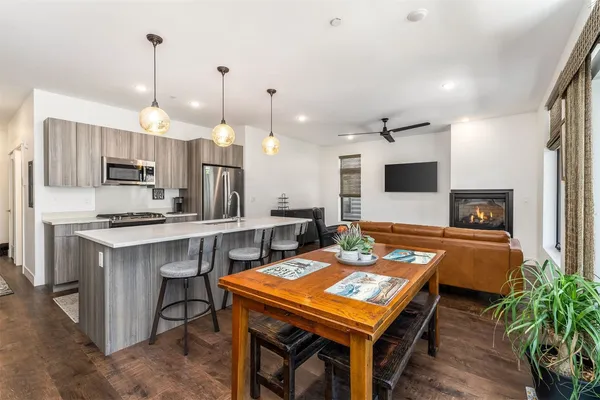 a kitchen with a table chairs refrigerator and microwave