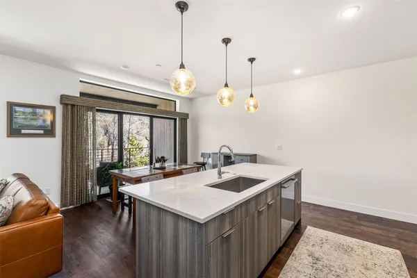 a kitchen with a sink a counter space and a chandelier