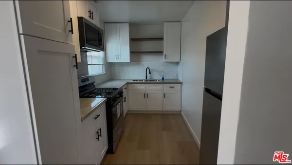a kitchen with a sink a stove top oven and refrigerator