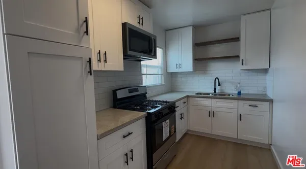 a kitchen with stainless steel appliances a sink stove and microwave