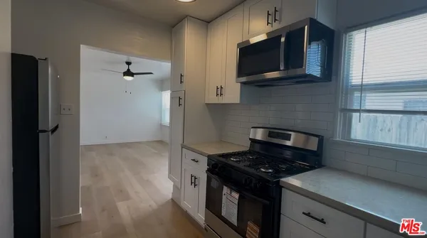 a kitchen with stainless steel appliances granite countertop a stove and a microwave