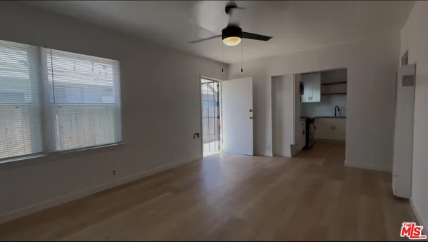 a view of a room with a ceiling fan and window