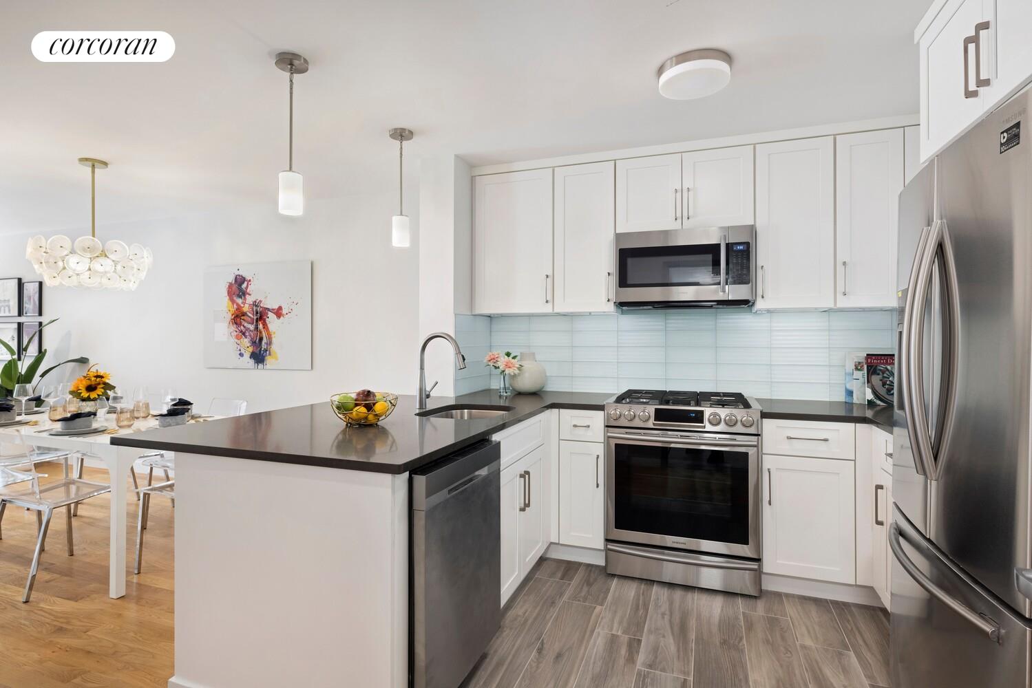 23-16 31st Avenue, Unit 2B Queens, NY 11106 - Photo 3 of 10 a kitchen with stainless steel appliances granite countertop a sink stove a refrigerator and a microwave