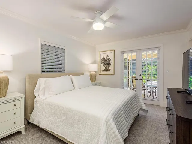 a bedroom with a large bed and a chandelier