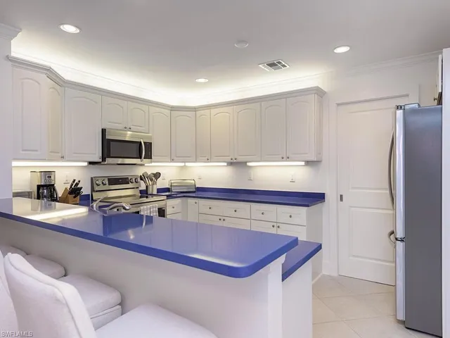 a kitchen with stainless steel appliances granite countertop a sink refrigerator and microwave