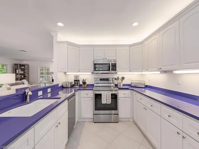 a kitchen with cabinets appliances a sink and a counter top space