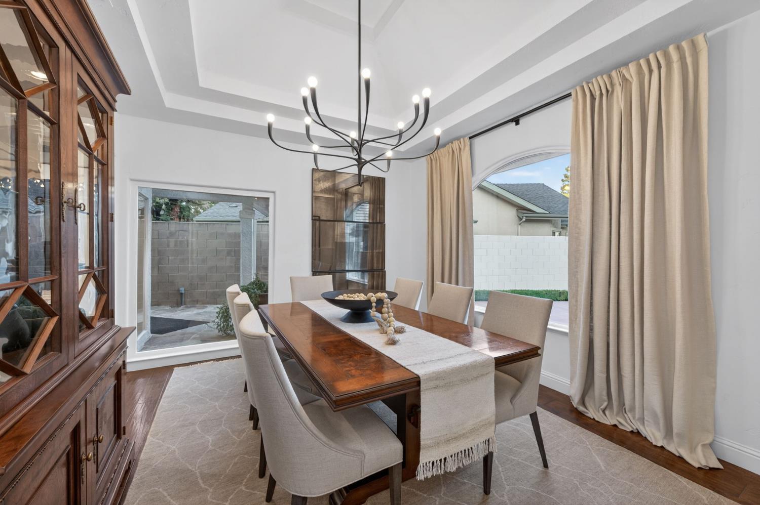 601 Decatur Avenue Clovis, CA 93611 - Photo 20 of 62 a dining room with wooden floor a chandelier a wooden table and chairs