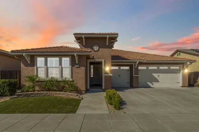 a front view of a house with a garden and plants