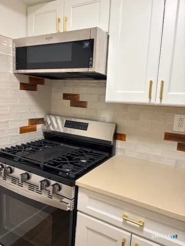 a stove top oven sitting inside of a kitchen