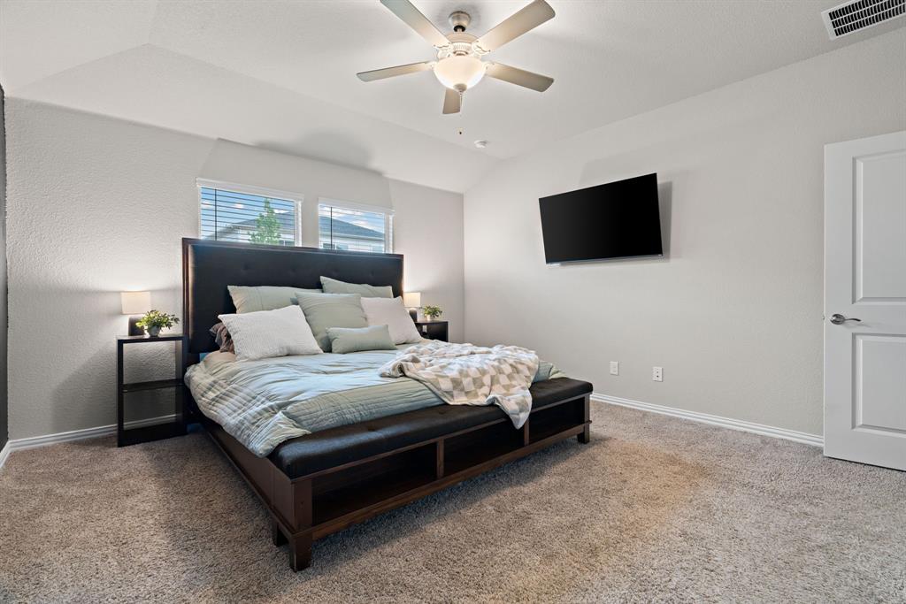 3112 Kingsgarden Road Denton, TX 76207 - Photo 27 of 38 Spacious bedroom featuring vaulted ceilings, a ceiling fan with integrated lighting, textured wall finishes, and light-colored carpeting
