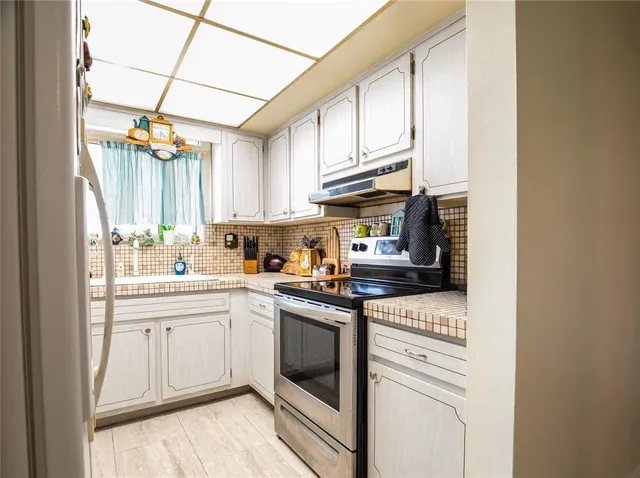 a kitchen with stainless steel appliances granite countertop a sink a stove and cabinets