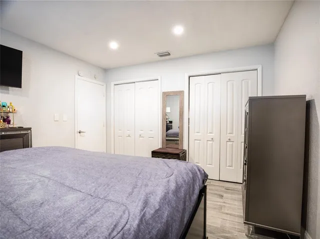 a large bedroom with a bed and a flat screen tv